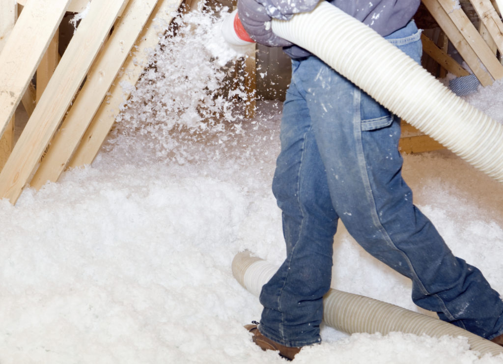 Knauf fiberglass insulation being blown into an attic.