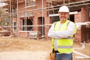 IBP of Miami employee standing in front of a new construction building project.