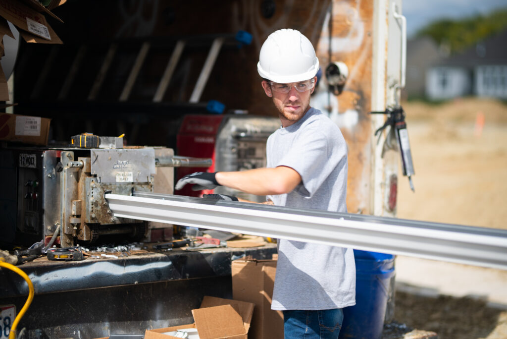 An installer makes seamless gutters with a roll former machine on-site at a new build home.